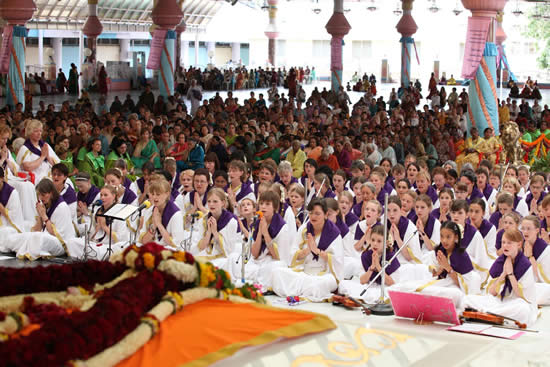 Children from Germany who participated in the Summer Course 2010 along with other youth, parents and teachers have come on a pilgrimage to Prasanthi Nilayam. They had an opportunity to perform a musical programme titled "Religions are Many. God is one." The programme started at 1700hrs. A few representatives offered roses to Bhagawan. The German devotees then astounded the assembly with clear vedic recitation of Sikshavalli. They concluded the recitation with Sahana Vavatu...